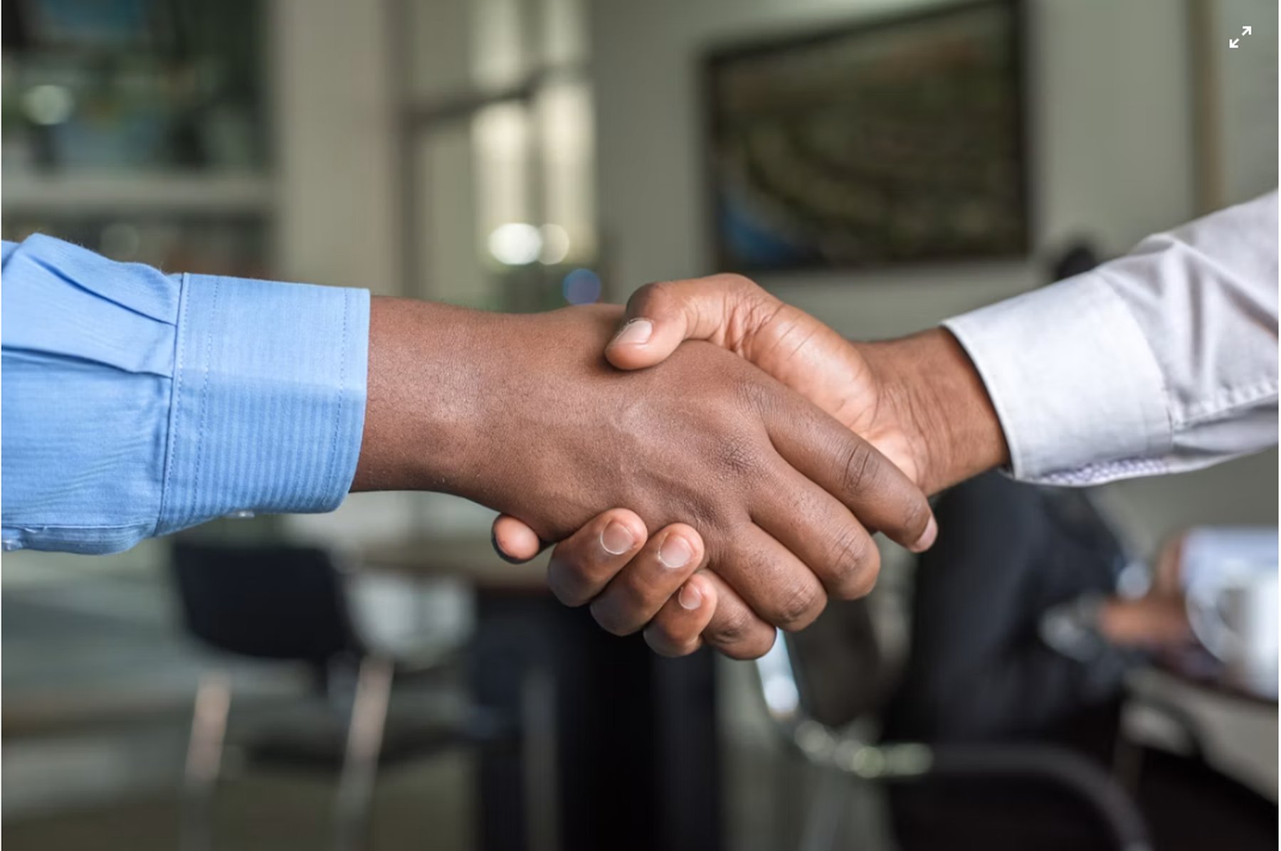 Stretta di mano tra due professionisti in ufficio